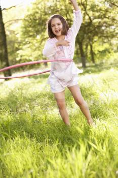 Young Girl Walking Playing With Hula Hoop In Summer Field