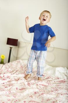 Young Boy Bouncing On Bed