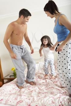 Family Bouncing On Bed Together