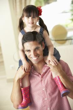 Father Giving Daughter Ride On Shoulders Indoors