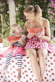 Mother And Daughter Enjoying Slices Of Water Melon