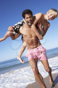 Father And Son Having Fun On Beach