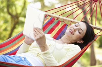 Woman Relaxing In Hammock With  E-Book