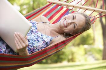 Woman Relaxing In Hammock With Laptop