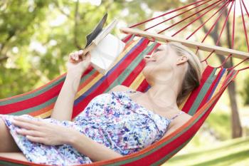 Woman Relaxing In Hammock With Book