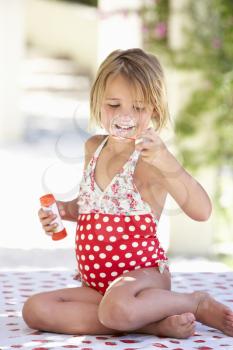 Girl Wearing Swimming Costume Blowing Bubbles