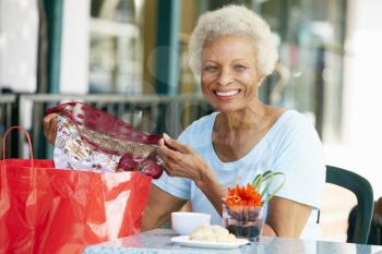 Senior Woman Enjoying Snack At Outdoor Caf After Shopping