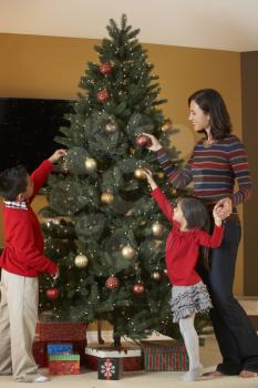 Mother And Children Decorating Christmas Tree