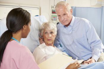 Nurse Talking To Senior Couple On Ward