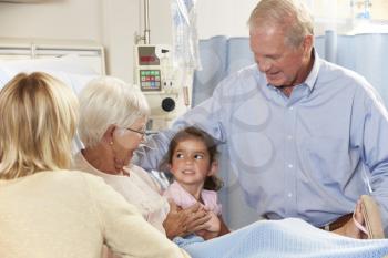 Family Visiting Senior Female Patient In Hospital Bed