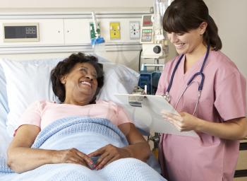 Nurse Visiting Senior Female Patient On Ward