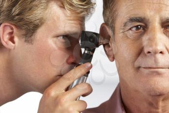 Doctor Examining Male Patient's Ears
