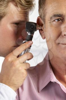 Doctor Examining Male Patient's Ears