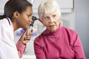 Doctor Examining Senior Female Patient's Ears
