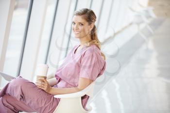 Female Nurse Using Digital Tablet On Coffee Break In Hospital