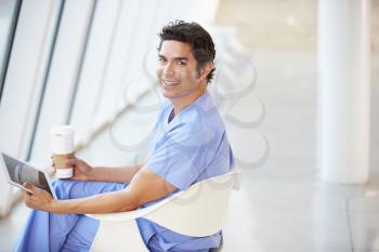 Doctor Using Digital Tablet On Coffee Break In Hospital