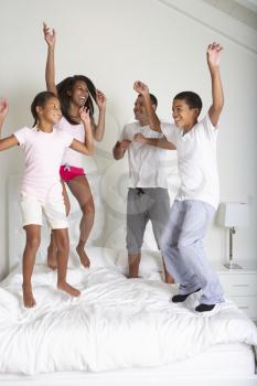 Family Jumping On Bed Together