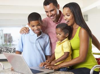 Family Using Laptop In Kitchen Together