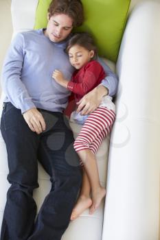 Overhead View Of Father And Daughter Relaxing On Sofa