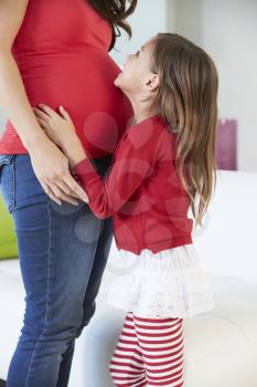 Daughter Listening To Pregnant Mother's Stomach