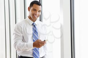 Businessman Using Mobile Phone In Office