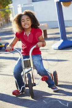 Child Riding Tricycle In Playground