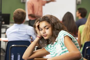 Bored Female Teenage Pupil In Classroom