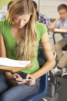 Female Pupil Sending Text Message In Classroom