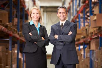 Businesswoman And Businessman In Distribution Warehouse