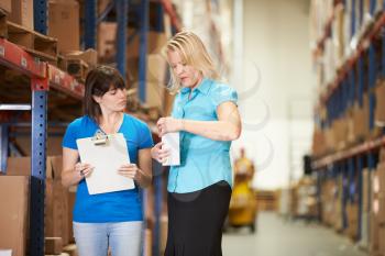 Businesswoman And Female Worker In Distribution Warehouse