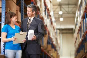 Businessman And Female Worker In Distribution Warehouse