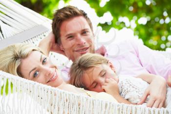 Family Relaxing In Beach Hammock With Sleeping Daughter