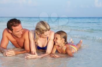 Family Lying In Sea On Tropical Beach Holiday