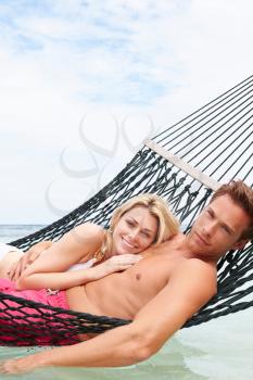 Couple Relaxing In Beach Hammock