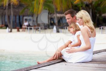 Family Sitting On Wooden Jetty