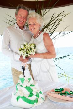 Senior Beach Wedding Ceremony With Cake In Foreground