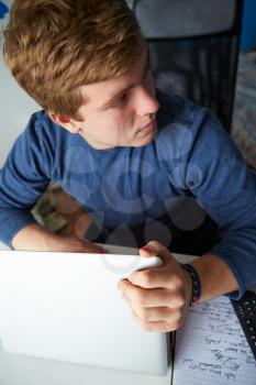 Teenage Boy Behaving Suspiciously Whilst Using Laptop
