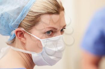 Nurse In Operating Theatre Wearing Scrubs And Mask
