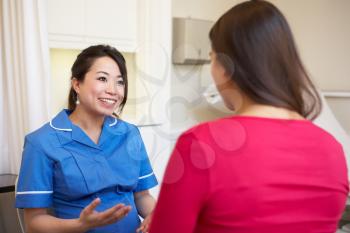 Pregnant Woman Meeting With Nurse In Clinic