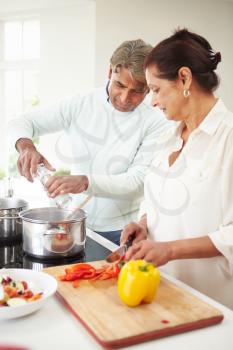 Senior Indian Couple Cooking Meal At Home