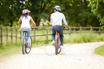 Indian Couple On Cycle Ride In Countryside