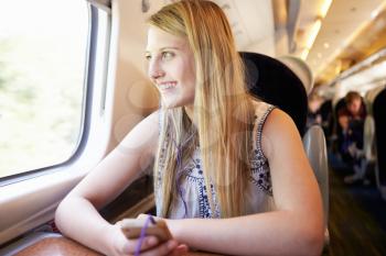 Teenage Girl Listening To Music On Train Journey