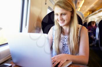 Teenage Girl Using Laptop On Train Journey