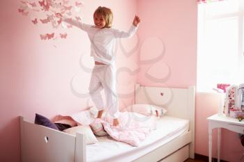 Young Girl Jumping On Her Bed