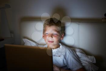Boy Using Laptop In Bed At Night