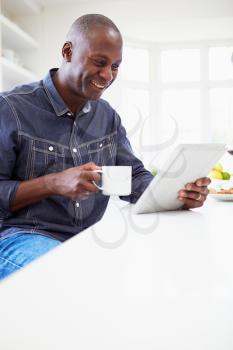 African American Man Using Digital Tablet At Home