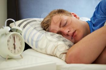 Teenage Boy Sleeping Through Alarm