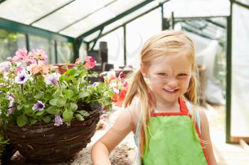 Girl Growing Plants In Greenhouse