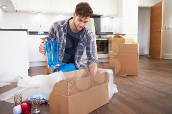 Man Moving Into New Home And Unpacking Boxes