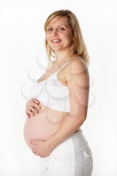 Studio Portrait Of 6 months Pregnant Woman Wearing White